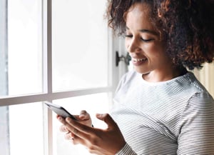 smiling-woman-using-a-smartphone-PJCP62Y-low